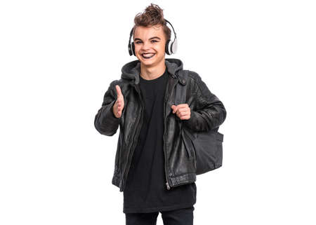 Portrait of teen boy student in headphones with spooking make-up holds bag, isolated on white background. Teenager with backpack in style of punk goth dressed in black. Problems of transitional ageの写真素材