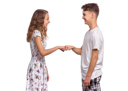 Portrait of happy teen boy and girl handshaking. Young attractive couple isolated on white background. Brother And sister with smile shake hands. Friendship and love conceptの写真素材