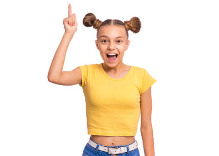 Portrait of smiling teen girl pointing a great idea, isolated on white background. Awesome idea. Beautiful young teenager keeping finger up, looking at camera. Happy cute child have unexpected ideaの写真素材