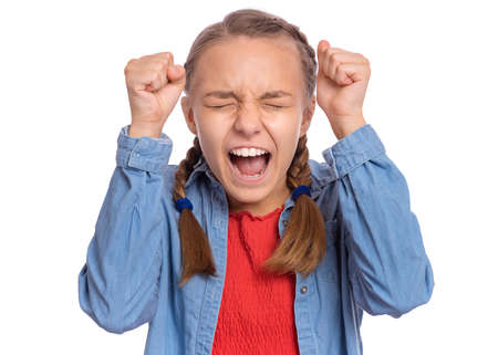 Happy teenage girl looking very happy holding fingers crossed for good luck, isolated on white backgroundの写真素材