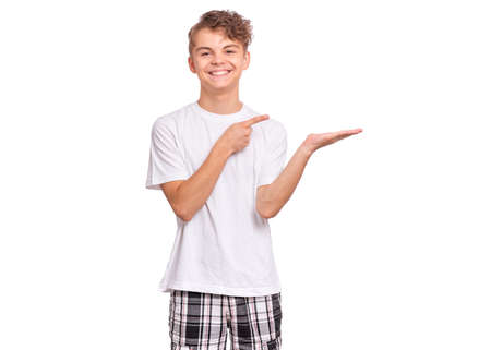Cute teen boy pointing up, gesturing idea or doing number one gesture, isolated on white backgroundの写真素材