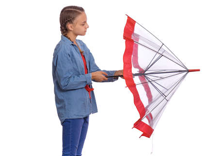 Beautiful teenage girl holding umbrella in hands, isolated on white backgroundの写真素材