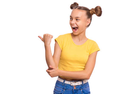 Portrait of teen girl pointing fingers up at copyspace, isolated on white background. Beautiful caucasian young teenager attracted by attention at something. Surprised or amazed childの写真素材