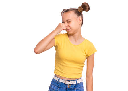 Beautiful teenage girl holding her nose because of a bad smell, isolated on white backgroundの写真素材