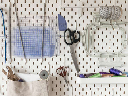 White pegboard with sewing supplies. Concept of tailoring and needlework, ergonomic storageの写真素材