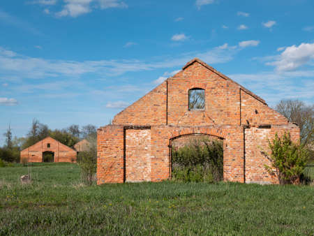 Scenic landscape with similar facades of abandoned houses. Two fronts of ruined brick buildings