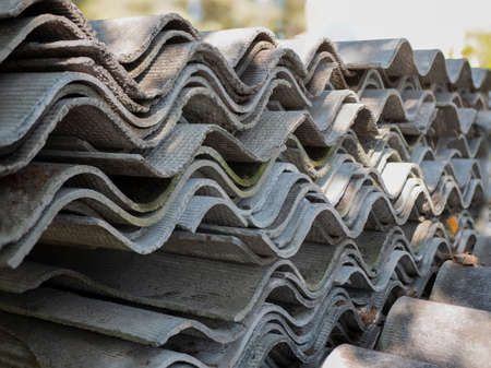 Stacked sheets of slate. Corrugated asbestos-cement sheets. Health-threatening roofing materialsの写真素材