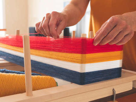 Weaver is winding a warp for weaving using the warping frame, selective focus