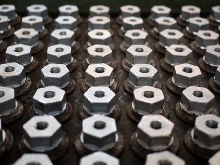 Ranks of the metal hex bolts, selective focus. Production of the fasteners, manufacturing industryの写真素材