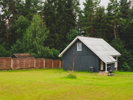 Picturesque nordic landscape with a wooden house in scandinavian style and front grassplot. Concept of simplicity, tranquility, harmonyの写真素材