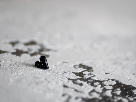 Black heart on a concrete background, selective focus. Concept of morbidity, sorrow, anxiety, unrequited love, affectionの写真素材
