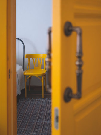 Edge of the bed and a next standing chair from half-open door, selective focus. Concept of care of bed-ridden patientの写真素材