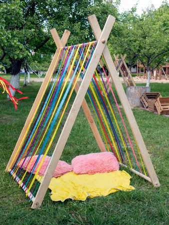 Rest or play tents made of multicolored ribbons with pillows and blanket outdoor, selective focus. Ideal place to relax for kids and adultsの写真素材