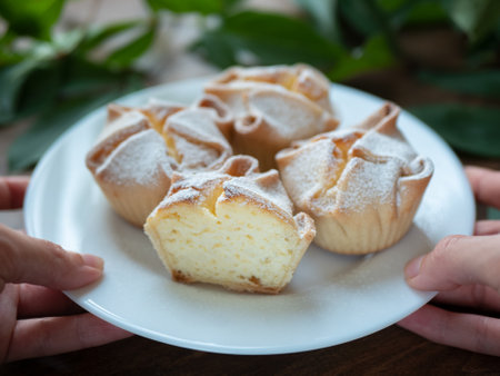 Plate of Soffioni Abruzzesi cakes in hands, selective focus. Freshly baked classic Italian cupcakes