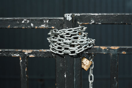 Chain wrapped around a gate and closed with a padlockの写真素材