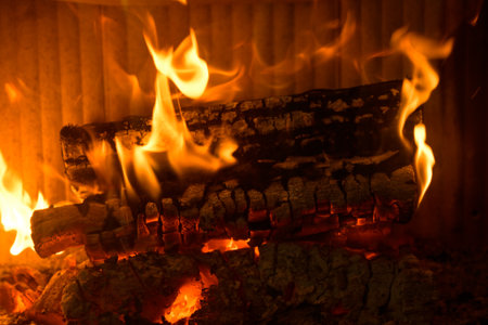 Logs of wood burning in the hearth of a fireplace