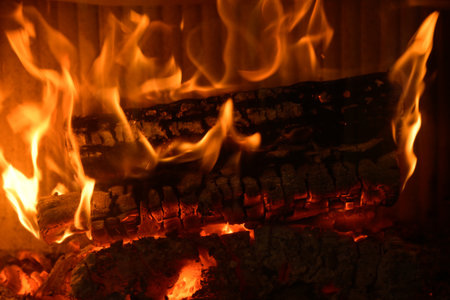 Logs of wood burning in the hearth of a fireplace