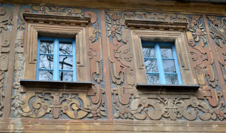 A photo of the architecture showing two windows in a tenement house covered with a bas-reliefの写真素材