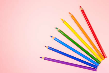 rainbow of colored pencils on a pink background.の写真素材