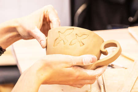 women's hands make a clay mug.の写真素材
