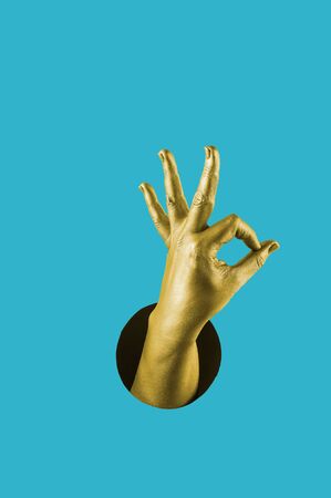 Hand painted in gold shows different gestures and symbols from the hole on a bright blue paper background. Creative template for design. 
の写真素材