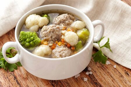 Hot thick soup with meatballs and cabbage mix. A large serving is served on a white plate. Ready to eat. Close up and horizontal orientation. 
の写真素材