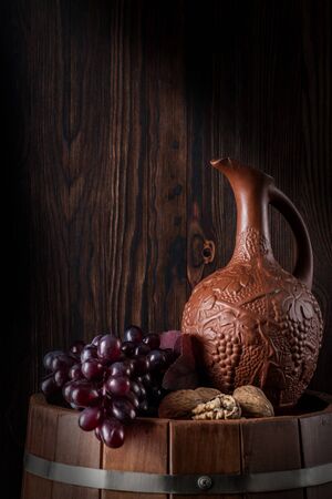Old red wine in jug and a glass. Traditional production and storage of wine. Close up and vertical orientation. Copy space.の写真素材