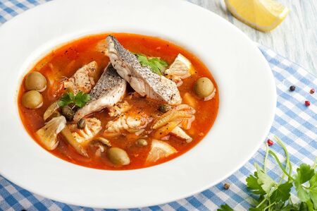 Fish soup. Traditional Mediterranean cuisine soup. Serving in a white plate ready to eat. Close up and horizontal orientation. の写真素材