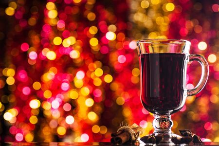 Hot mulled wine. Christmas drink on a background of bokeh of bright lights. Space for text. の写真素材