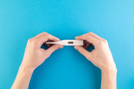 Hands hold a set of hygienic antiseptics and medications on a blue background. Antibacterial...
