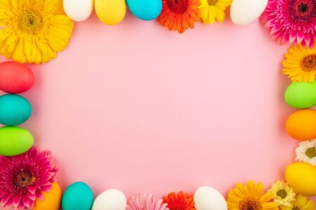 Beautiful easter eggs painted in yellow, red and green pastel colors on a pink background in a...