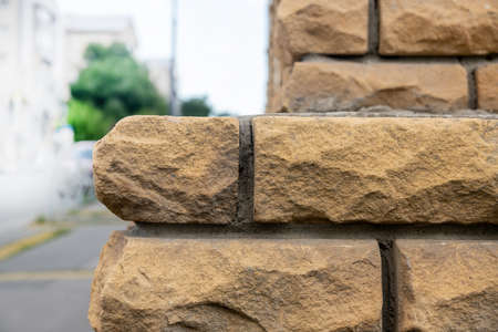 Brick wall of a building outside. Beautiful masonry of a street wall made of bricks and cement.