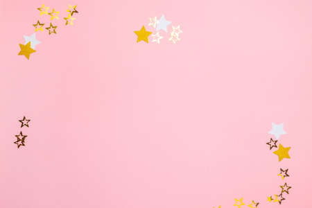 Christmas background. Decorative ornaments in the form of stars lie on a pastel pink background....