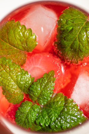Summer refreshing cocktail with strawberries, ice and fresh mint leaves. Large glass with lemonade close-up.の写真素材