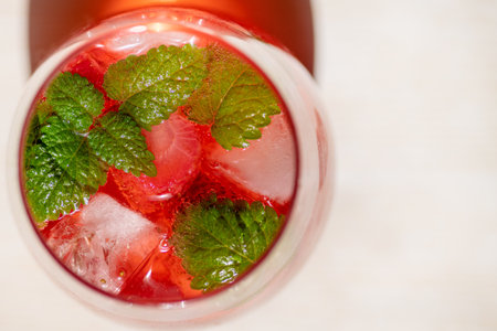 Summer refreshing cocktail with strawberries, ice and fresh mint leaves. Large glass with lemonade close-up.の写真素材