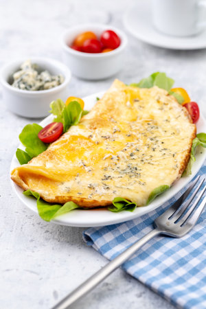 Fried eggs with cheese, cherry tomatoes and fresh lettuce. Omelet with filling for breakfast. Healthy or ketogenic or no carbohydrate food concept.の写真素材