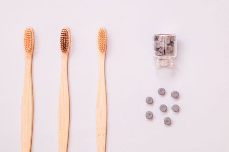 Bamboo toothbrush and dry tooth paste or toothpaste tablets on blue background. Zero waste, ecological concept.の写真素材