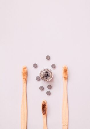 Bamboo toothbrush and dry tooth paste or toothpaste tablets on blue background. Zero waste, ecological concept.の写真素材