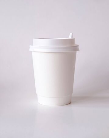 Mock up coffee or tea paper cup with cap on a light background. Logo Templateの写真素材