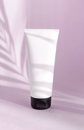 Creative minimalistic shot of a cosmetic product. Spa concept. Natural organic cosmetic packaging plastic mock up with shadow palm leaves. Mock-up bottle for branding and label.の写真素材