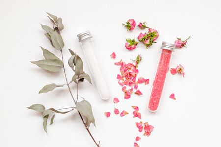 Spa or wellness. Pink salt with a rose and white sea salt in cones on a light background. Rose petals and dried budsの写真素材