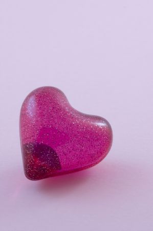 A love heart isolated on a pastel pink backgroundの写真素材