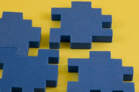 Blue puzzle Pieces on a yellow backgroundの写真素材