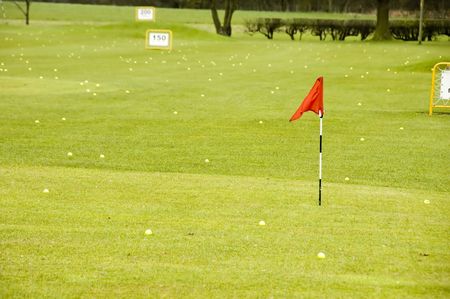 A view of a driving range with flags fluttering in the windの写真素材