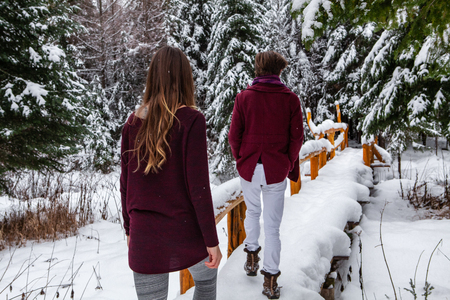 Pictured from the back with blurry fir trees full of snow in the background.の写真素材