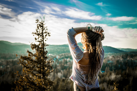 Girl on the top of a mountain with the sun
