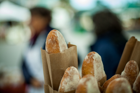 Baguette breads in paper bags at farmer's marketの写真素材