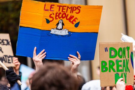 Climate change sign at ecological rally. A french sign shows a picture of a penguin on a melting ice...