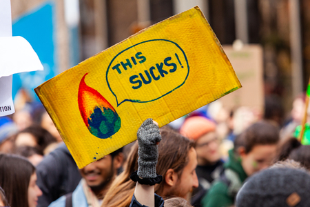 Demonstrator sign at ecological rally. A French sign reads this sucks, and depicts planet earth burning. Conceptual sign held by a demonstrator during an ecological activism march.のeditorial素材