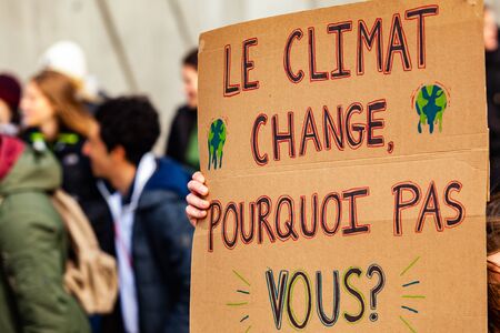 A French poster is viewed close-up, saying the climate is changing, why not you, as during an ecological activism march on a street in Montreal, Canadaの写真素材